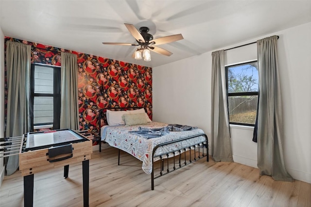 326 W Mulberry St, Fredericksburg, TX 78624 - bedroom with ceiling fan, an accent wall, wood finished floors, and wallpapered walls