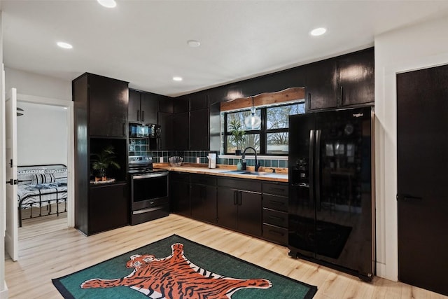 326 W Mulberry St, Fredericksburg, TX 78624 - kitchen with dark cabinetry, a sink, backsplash, and black appliances