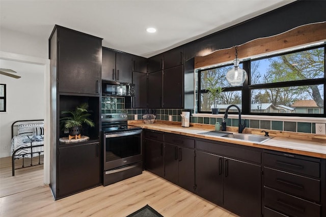 326 W Mulberry St, Fredericksburg, TX 78624 - kitchen featuring black microwave, stainless steel electric stove, a sink, and light wood-style floors