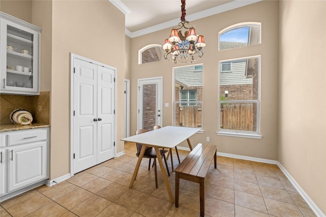 814 Arrowhead Trl, Cedar Park, TX 78613 - dining room featuring crown molding, a chandelier, light tile patterned floors, baseboards, and a towering ceiling