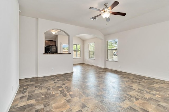 unfurnished living room with visible vents, baseboards, arched walkways, and ceiling fan