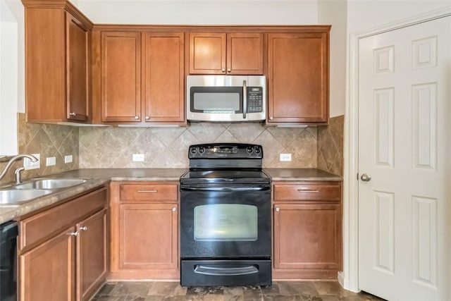 kitchen featuring a sink, brown cabinets, black appliances, and tasteful backsplash