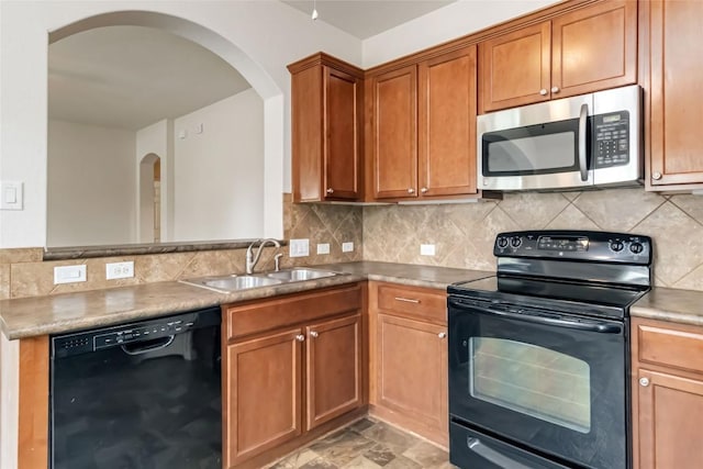 kitchen with decorative backsplash, arched walkways, a sink, and black appliances