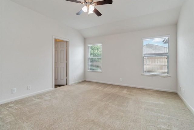 spare room with ceiling fan, light carpet, and baseboards