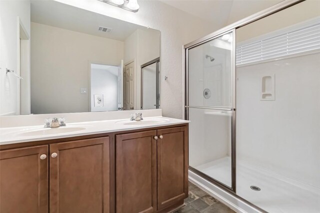 bathroom with double vanity, a sink, visible vents, and a stall shower