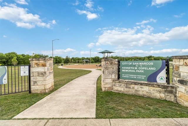 view of property's community with fence and a lawn