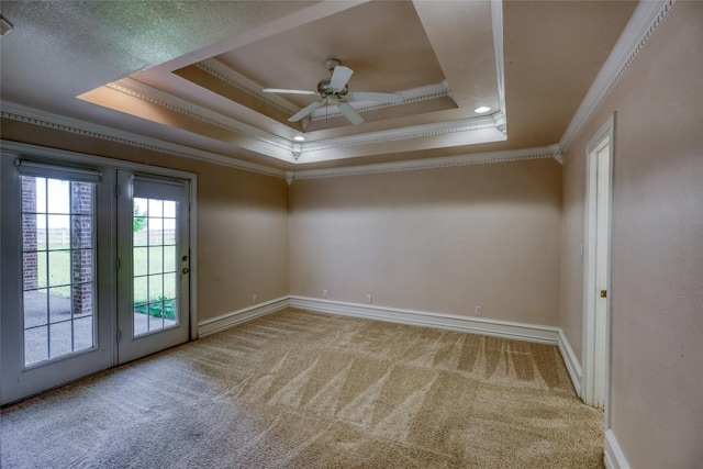 spare room featuring ceiling fan, carpet flooring, a raised ceiling, and ornamental molding