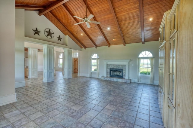 unfurnished living room with wood ceiling, baseboards, a fireplace with raised hearth, and high vaulted ceiling