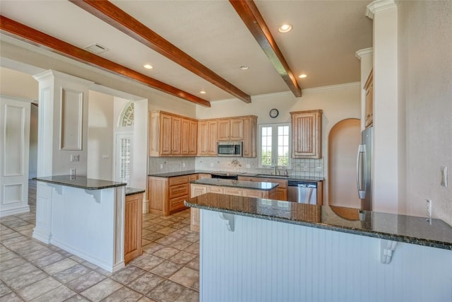 kitchen featuring beam ceiling, decorative backsplash, a peninsula, a kitchen bar, and appliances with stainless steel finishes