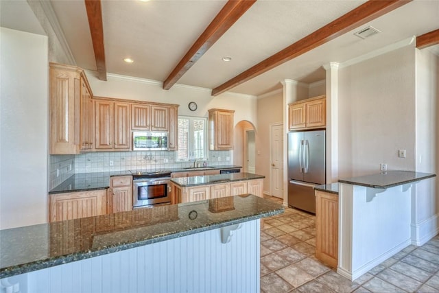 kitchen featuring a peninsula, backsplash, appliances with stainless steel finishes, and beamed ceiling