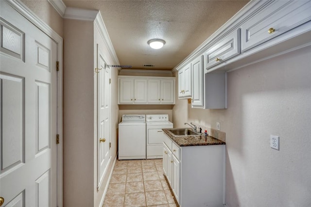 clothes washing area featuring washer and clothes dryer, ornamental molding, a sink, cabinet space, and a textured ceiling