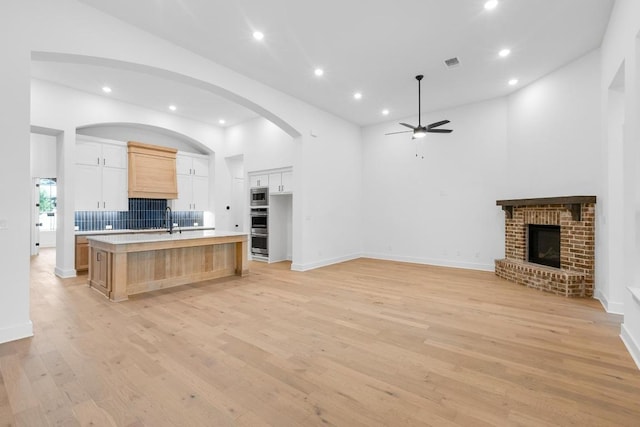 394 Leaning Rock Rdg, Austin, TX 78737 - kitchen with a ceiling fan, light countertops, a large island with sink, light wood finished floors, and open floor plan