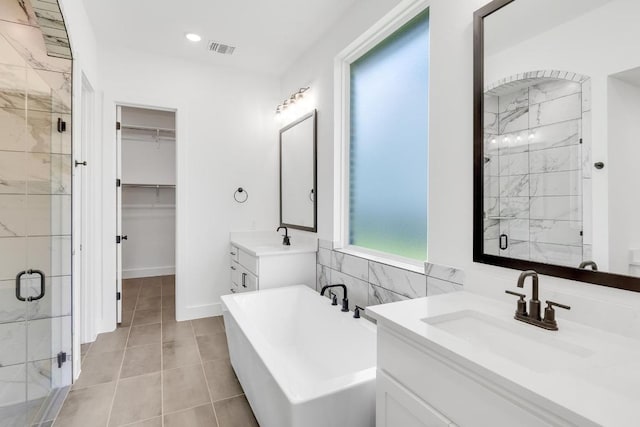 394 Leaning Rock Rdg, Austin, TX 78737 - bathroom featuring a shower stall, a soaking tub, two vanities, a spacious closet, and tile patterned flooring