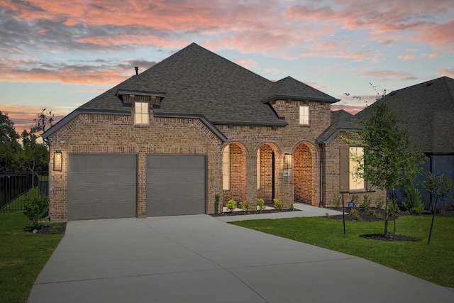 394 Leaning Rock Rdg, Austin, TX 78737 - french country home featuring concrete driveway, roof with shingles, brick siding, and an attached garage