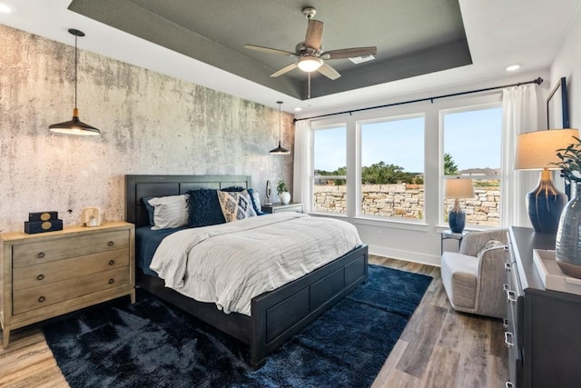 237 San Xavier St, Georgetown, TX 78633 - bedroom featuring a raised ceiling, wood finished floors, recessed lighting, and baseboards