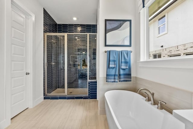237 San Xavier St, Georgetown, TX 78633 - bathroom featuring a freestanding bath, a stall shower, recessed lighting, and tile walls