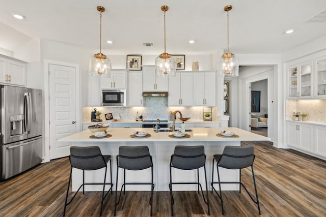 237 San Xavier St, Georgetown, TX 78633 - kitchen with appliances with stainless steel finishes, a kitchen bar, a sink, decorative backsplash, and recessed lighting