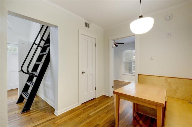 interior space with crown molding, visible vents, and light wood finished floors