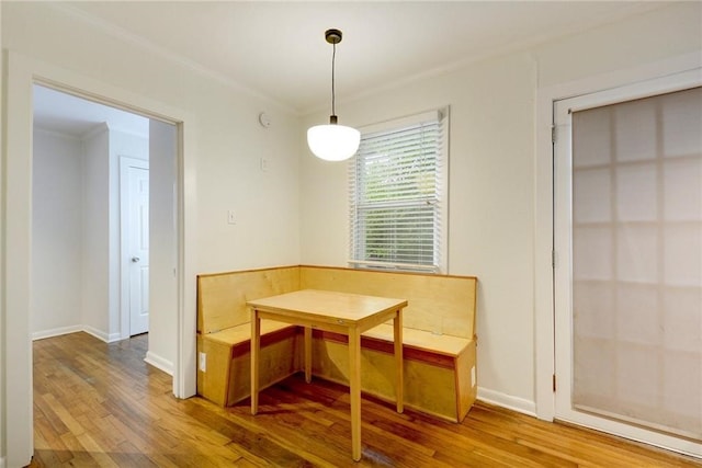 dining space with baseboards, crown molding, and wood finished floors