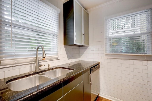 1110 W 22nd St Unit 13, Austin, TX 78705 - kitchen featuring stainless steel dishwasher, a sink, crown molding, tile walls, and dark stone counters