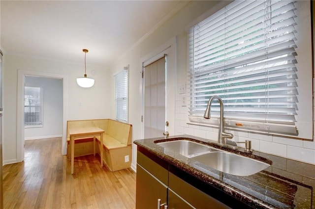 kitchen featuring decorative backsplash, a sink, and a healthy amount of sunlight