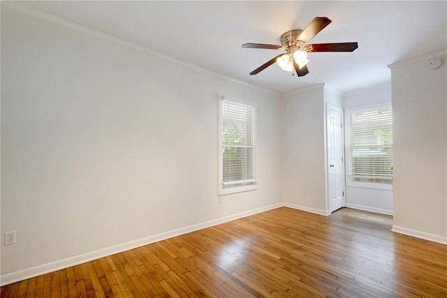 spare room featuring hardwood / wood-style floors, a ceiling fan, baseboards, and ornamental molding