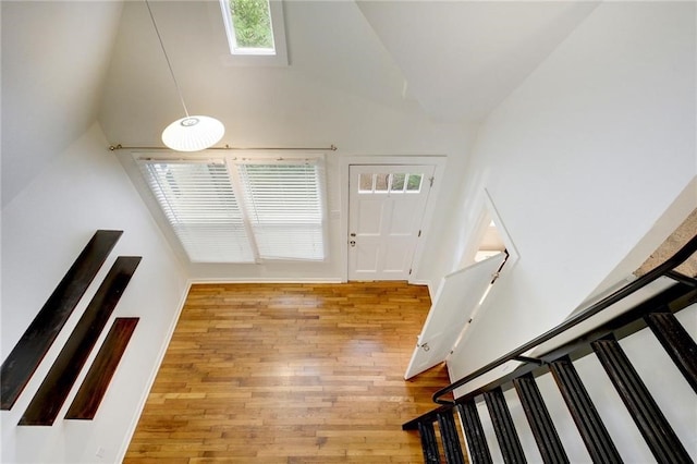 entrance foyer with wood finished floors and high vaulted ceiling
