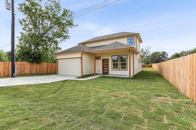 traditional-style house featuring roof with shingles, a fenced backyard, a front lawn, driveway, and an attached garage