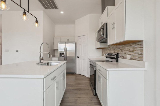 kitchen with stainless steel appliances, backsplash, wood finished floors, visible vents, and a sink