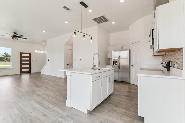 kitchen featuring stainless steel appliances, a sink, light wood-type flooring, visible vents, and a ceiling fan