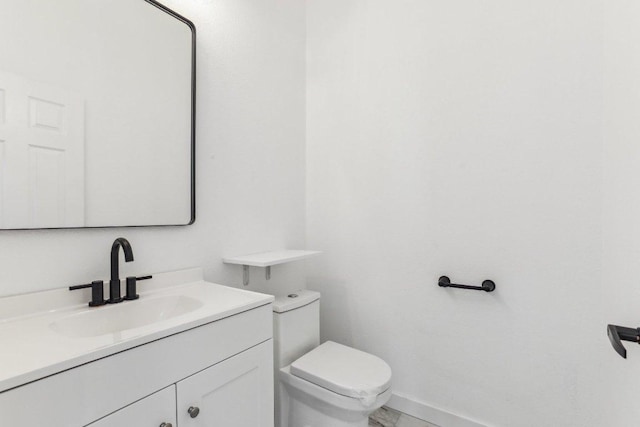 half bathroom with vanity and toilet