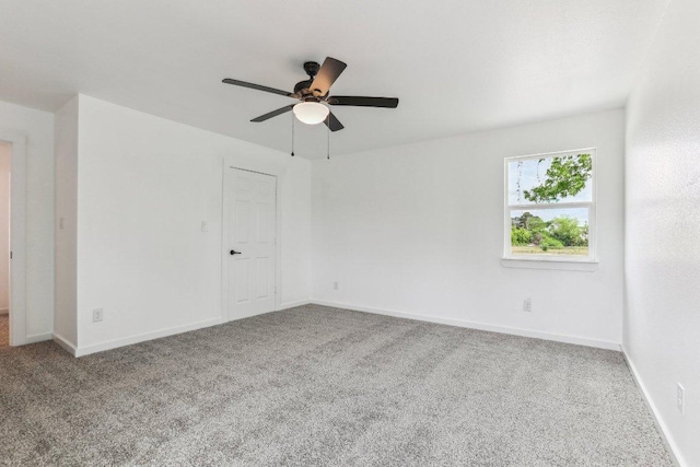 spare room featuring a ceiling fan, baseboards, and carpet