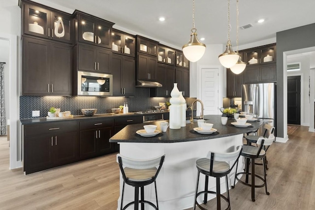 2104 Tobiano Trce, Georgetown, TX 78633 - kitchen featuring appliances with stainless steel finishes, dark countertops, decorative backsplash, and recessed lighting