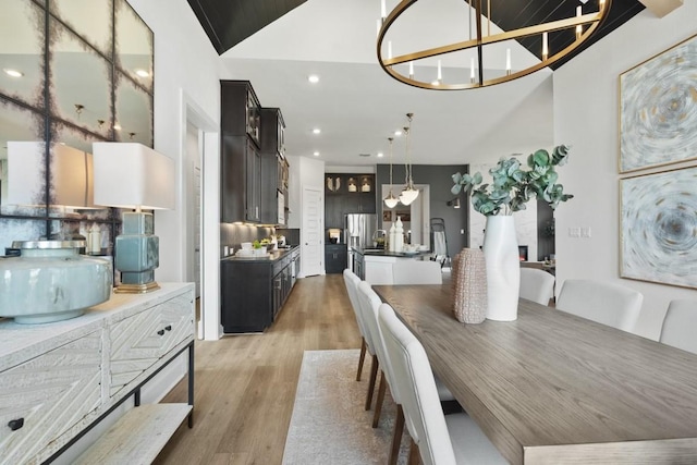 2104 Tobiano Trce, Georgetown, TX 78633 - dining area featuring light wood finished floors, recessed lighting, a chandelier, and high vaulted ceiling