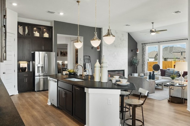 2104 Tobiano Trce, Georgetown, TX 78633 - kitchen with appliances with stainless steel finishes, dark countertops, a sink, a ceiling fan, and light wood-style floors