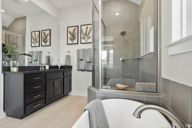 2104 Tobiano Trce, Georgetown, TX 78633 - full bath with a soaking tub, a shower stall, vanity, and recessed lighting