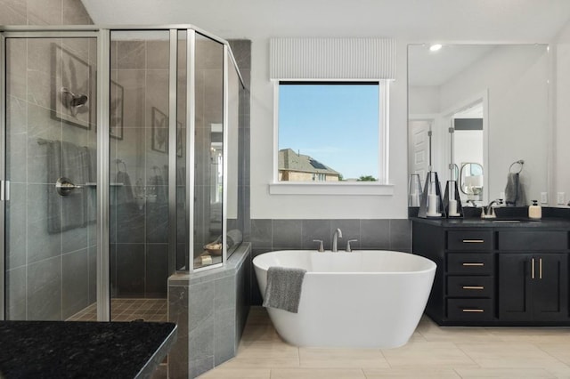 2104 Tobiano Trce, Georgetown, TX 78633 - full bath featuring a soaking tub, a stall shower, vanity, recessed lighting, and tile walls