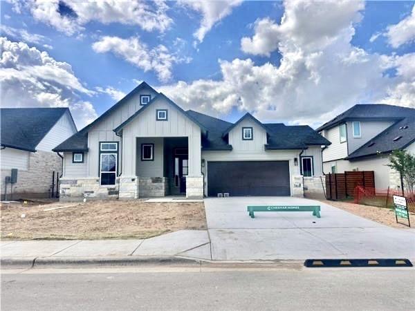 2104 Tobiano Trce, Georgetown, TX 78633 - view of front of property featuring board and batten siding, concrete driveway, an attached garage, and stone siding