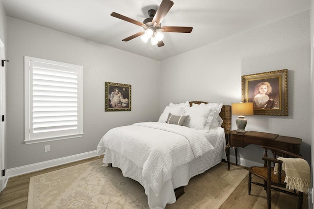bedroom with baseboards, a ceiling fan, and wood finished floors