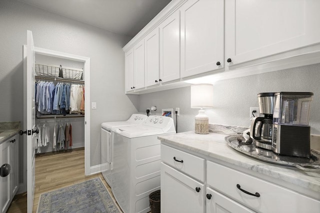 clothes washing area featuring cabinet space, independent washer and dryer, and light wood-type flooring