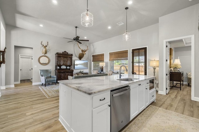 kitchen featuring stainless steel dishwasher, a sink, white cabinetry, light wood-style floors, and a ceiling fan