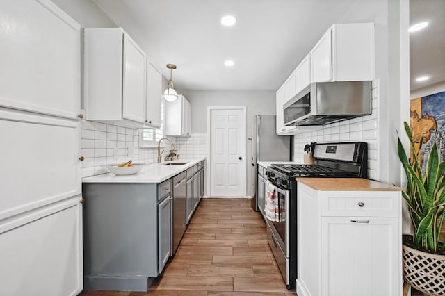 1213 S Trace Dr, Austin, TX 78745 - kitchen with stainless steel appliances, backsplash, light wood-style flooring, light countertops, and recessed lighting