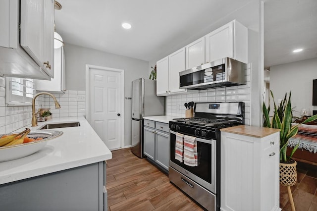 1213 S Trace Dr, Austin, TX 78745 - kitchen featuring tasteful backsplash, gray cabinets, stainless steel appliances, and a sink