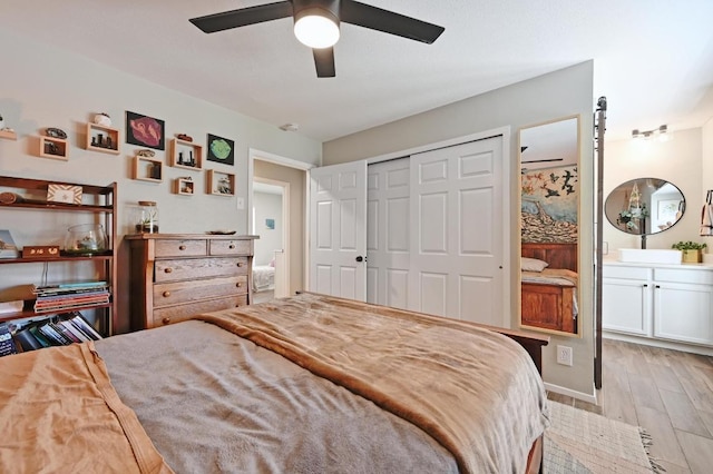 1213 S Trace Dr, Austin, TX 78745 - bedroom featuring ensuite bath, light wood-style flooring, a closet, and a ceiling fan