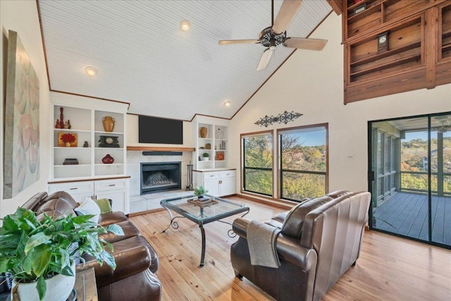 living room with recessed lighting, light wood-style floors, high vaulted ceiling, ceiling fan, and a fireplace