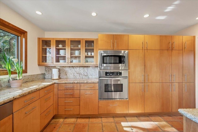 8509 Appalachian Dr, Austin, TX 78759 - kitchen with appliances with stainless steel finishes, light stone counters, glass insert cabinets, recessed lighting, and backsplash