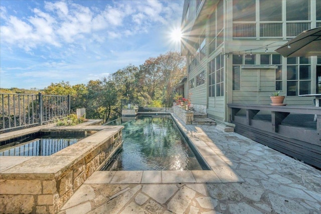 outdoor pool featuring fence and a patio