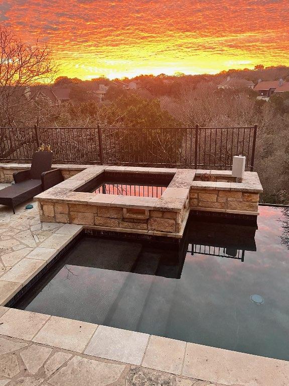 exterior space featuring fence and an in ground hot tub