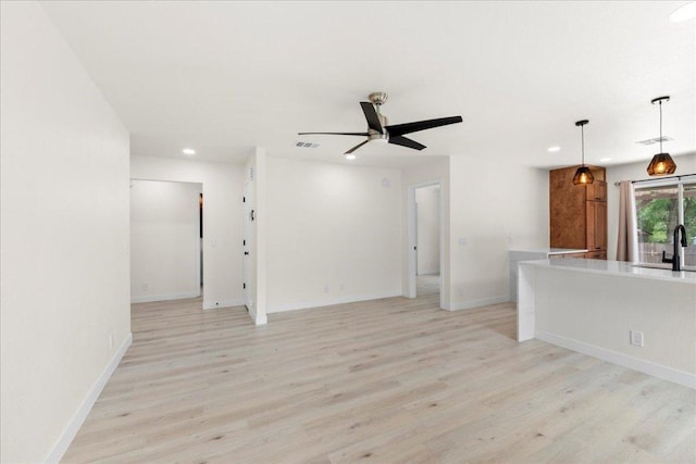 6007 Wideleaf Dr, Austin, TX 78724 - unfurnished living room with recessed lighting, a sink, a ceiling fan, visible vents, and light wood-style flooring