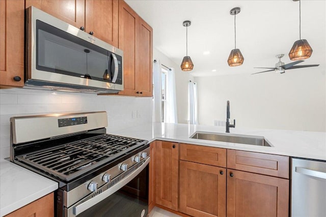 6007 Wideleaf Dr, Austin, TX 78724 - kitchen with a sink, light countertops, brown cabinetry, pendant lighting, and appliances with stainless steel finishes